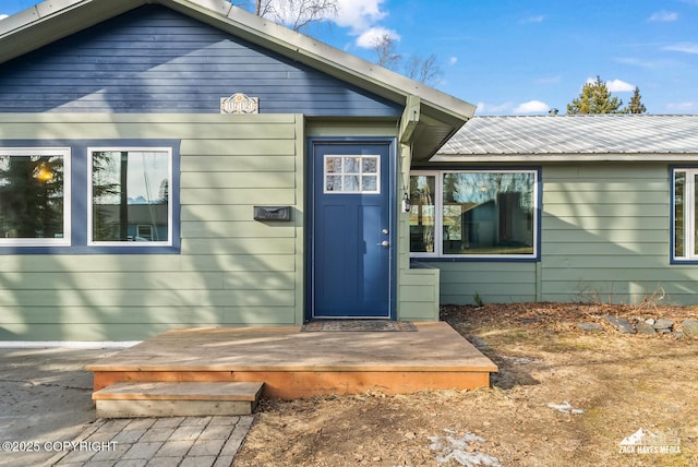 view of exterior entry featuring metal roof