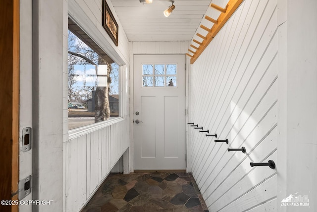 entryway featuring wooden walls and stone finish floor