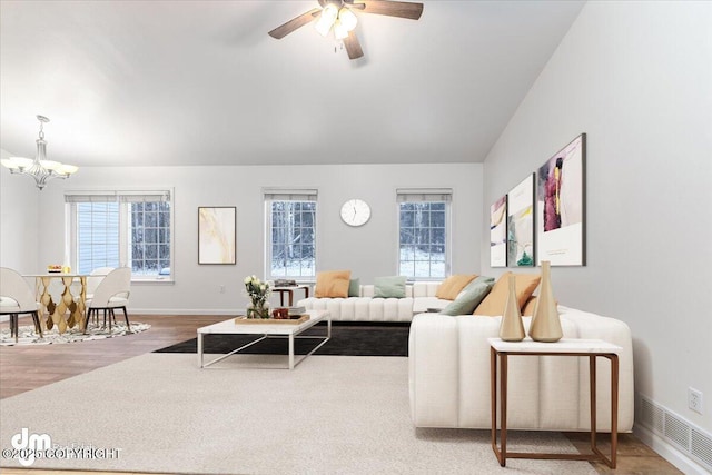 living room featuring hardwood / wood-style floors, ceiling fan with notable chandelier, and a healthy amount of sunlight