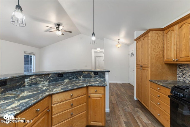 kitchen with lofted ceiling, dark wood-type flooring, dark stone countertops, black range with gas stovetop, and decorative light fixtures