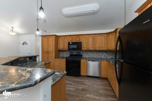 kitchen featuring dark wood-type flooring, a wall mounted air conditioner, decorative light fixtures, decorative backsplash, and black appliances