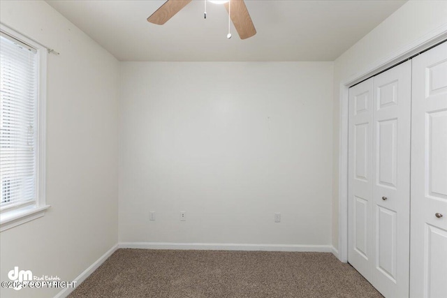 unfurnished bedroom featuring carpet flooring, ceiling fan, and a closet