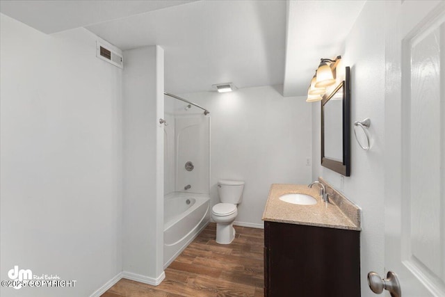 full bathroom featuring vanity, hardwood / wood-style flooring, toilet, and washtub / shower combination