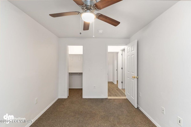 unfurnished bedroom with a spacious closet, carpet floors, a closet, and ceiling fan