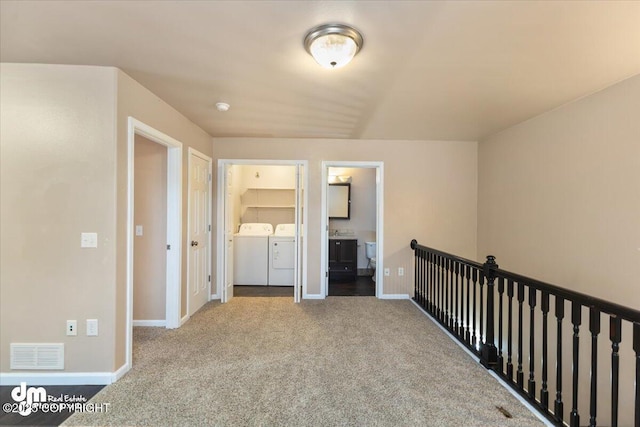 corridor with washing machine and dryer and carpet