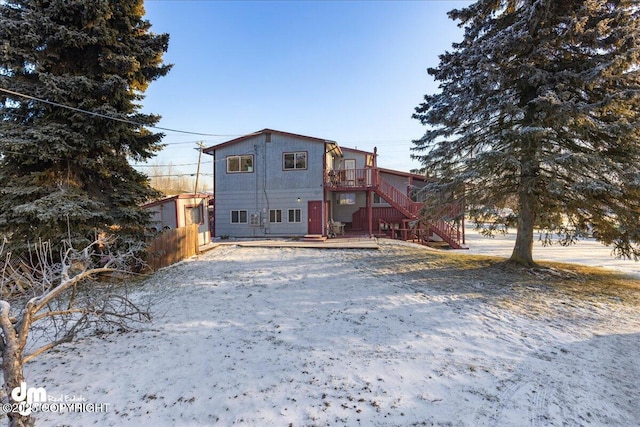 rear view of property with stairs, a wooden deck, and fence