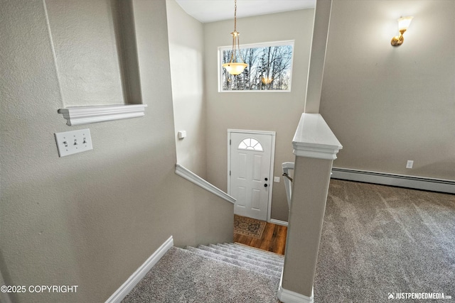 carpeted entryway with a baseboard radiator, stairs, and baseboards