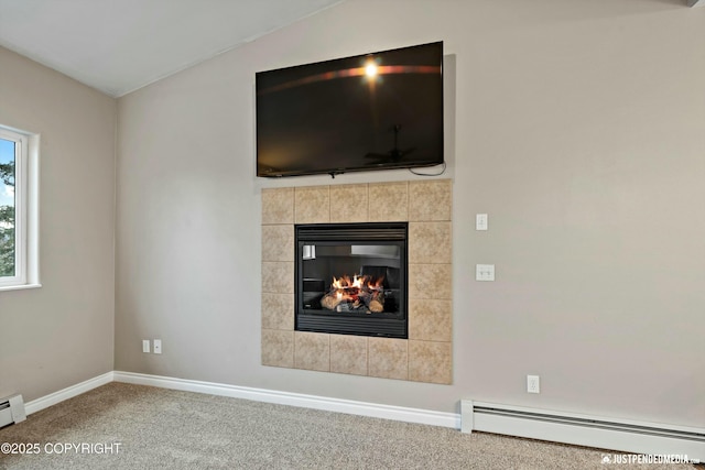 interior details featuring a tiled fireplace, a baseboard radiator, baseboards, and carpet