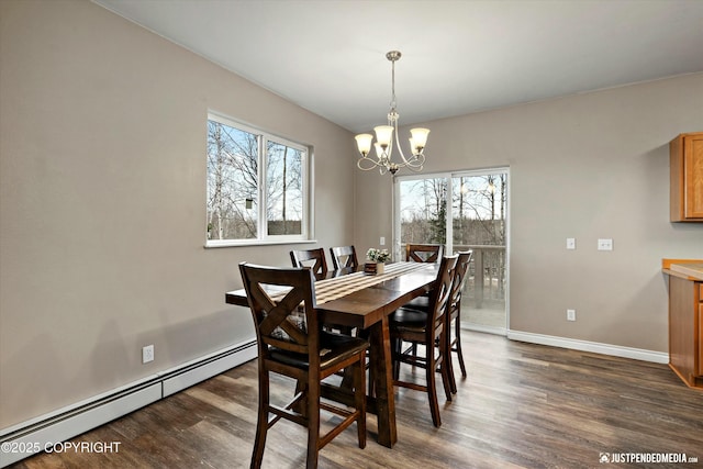 dining space with a baseboard heating unit, dark wood-style flooring, a wealth of natural light, and an inviting chandelier