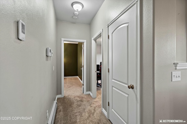 hallway featuring baseboards, baseboard heating, and carpet flooring