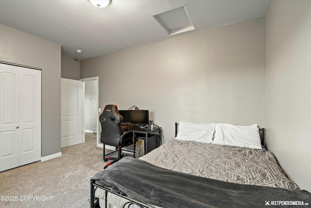 bedroom with carpet, attic access, baseboards, and a closet