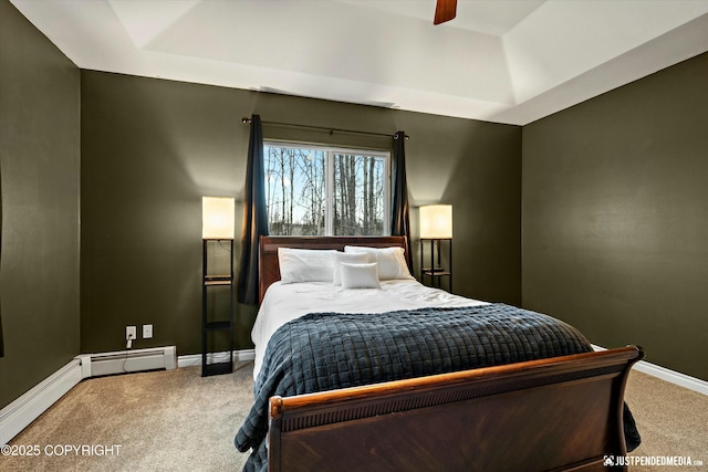 bedroom with carpet floors, baseboards, baseboard heating, and a raised ceiling