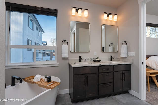 bathroom featuring vanity, a washtub, and tile patterned floors