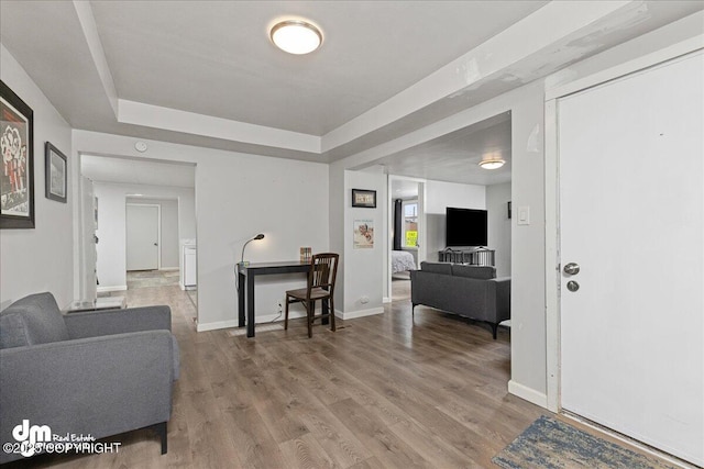 living room with a tray ceiling and hardwood / wood-style flooring