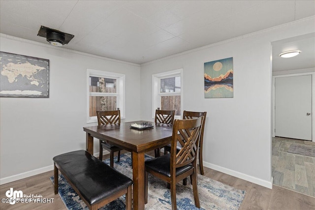 dining space featuring hardwood / wood-style flooring and crown molding