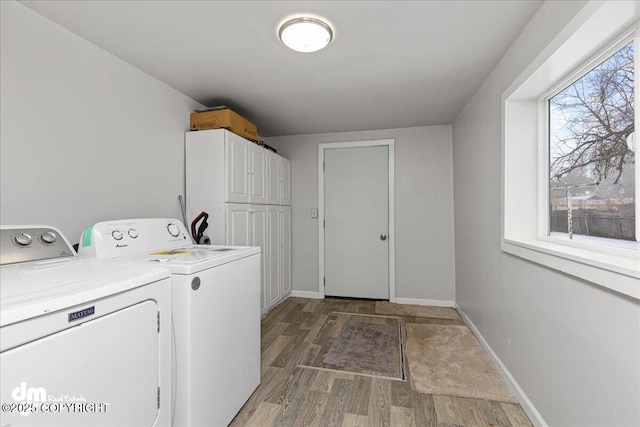 laundry room with cabinets, washing machine and dryer, and hardwood / wood-style floors