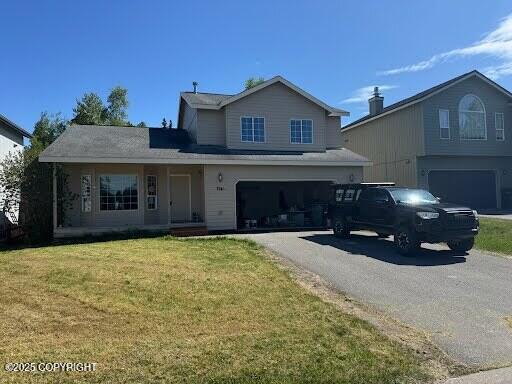7541 Florence Cir, Anchorage, AK 99507 - traditional-style house with a garage, asphalt driveway, and a front yard