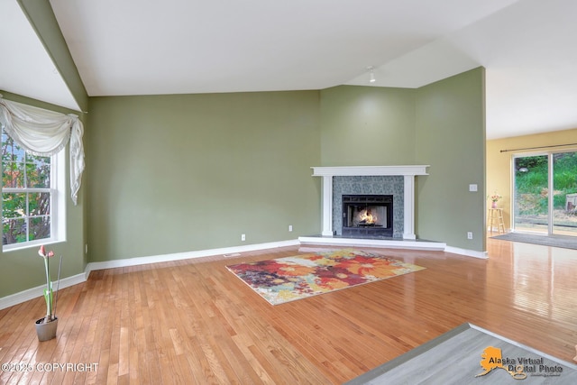 7541 Florence Cir, Anchorage, AK 99507 - unfurnished living room with lofted ceiling, wood-type flooring, baseboards, and a fireplace