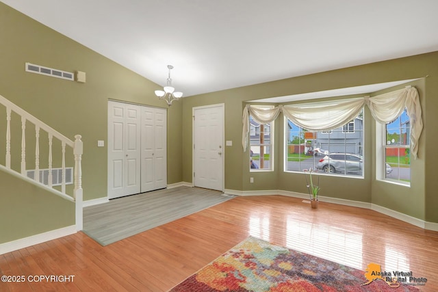7541 Florence Cir, Anchorage, AK 99507 - entryway with wood finished floors, stairs, a chandelier, vaulted ceiling, and baseboards