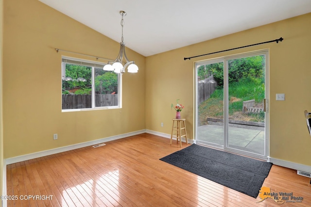 7541 Florence Cir, Anchorage, AK 99507 - empty room featuring hardwood / wood-style flooring, plenty of natural light, vaulted ceiling, and baseboards