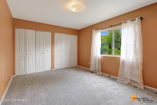 7541 Florence Cir, Anchorage, AK 99507 - unfurnished bedroom with two closets, baseboards, and carpet floors