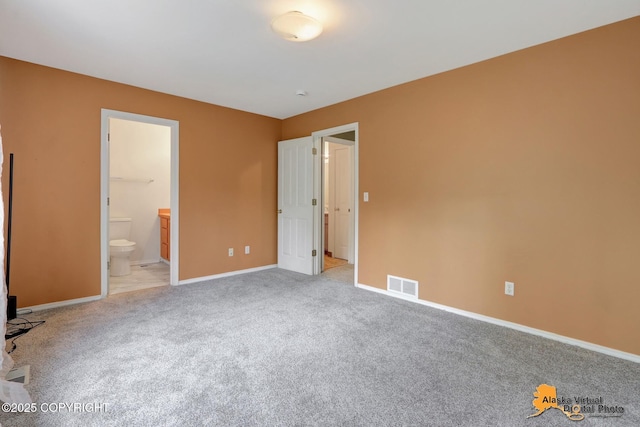 7541 Florence Cir, Anchorage, AK 99507 - unfurnished bedroom featuring light colored carpet, baseboards, and connected bathroom