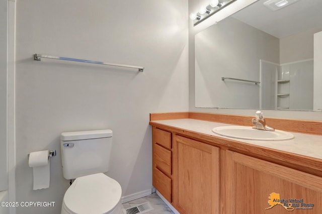 7541 Florence Cir, Anchorage, AK 99507 - full bath featuring vanity, toilet, marble look tiles, and a shower
