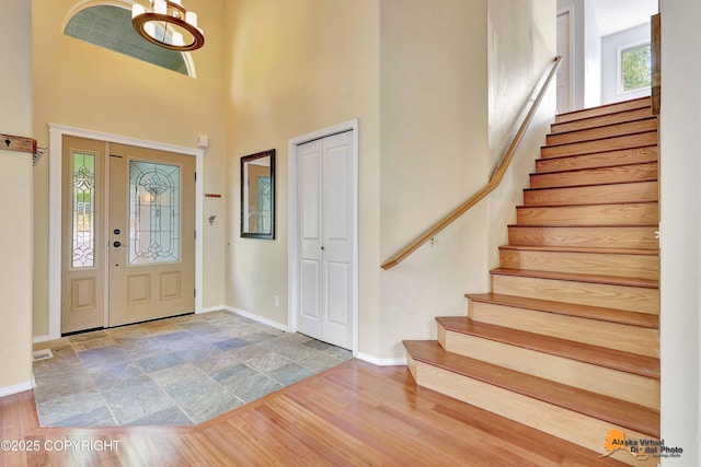 10235 Stewart Dr, Eagle River, AK 99577 - entryway with stairway, a high ceiling, wood finished floors, and a chandelier