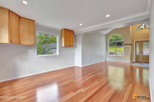 10235 Stewart Dr, Eagle River, AK 99577 - unfurnished living room featuring healthy amount of natural light, crown molding, light wood finished floors, recessed lighting, and a chandelier
