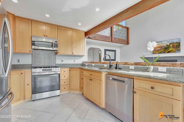 10235 Stewart Dr, Eagle River, AK 99577 - kitchen featuring stainless steel appliances, light brown cabinetry, light stone countertops, recessed lighting, and arched walkways
