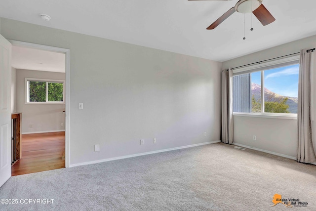 10235 Stewart Dr, Eagle River, AK 99577 - empty room featuring carpet floors, ceiling fan, plenty of natural light, and a smoke detector