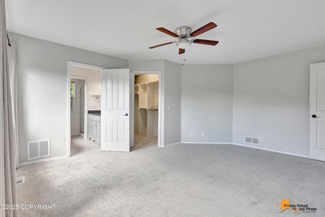 10235 Stewart Dr, Eagle River, AK 99577 - unfurnished bedroom with light colored carpet, a spacious closet, ensuite bath, a closet, and ceiling fan