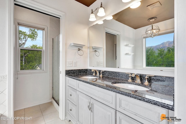 10235 Stewart Dr, Eagle River, AK 99577 - bathroom with double vanity, tile patterned flooring, tiled shower, and a chandelier