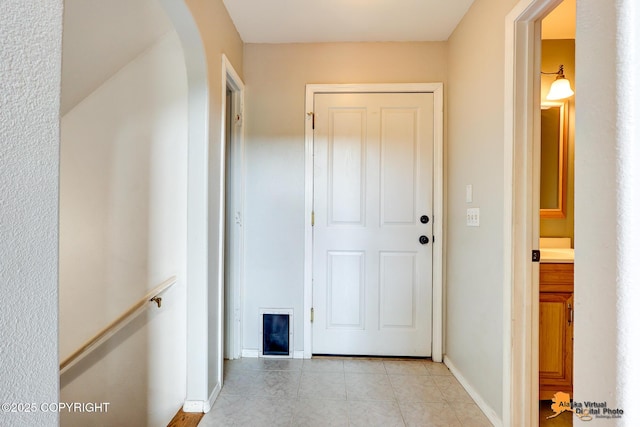 10235 Stewart Dr, Eagle River, AK 99577 - hallway with arched walkways, light tile patterned floors, and an upstairs landing