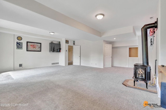 10235 Stewart Dr, Eagle River, AK 99577 - unfurnished living room featuring a wood stove and carpet flooring