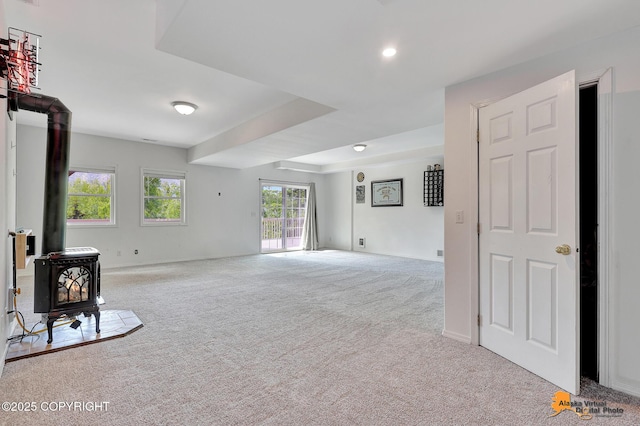 10235 Stewart Dr, Eagle River, AK 99577 - unfurnished living room featuring a wood stove, carpet flooring, and recessed lighting