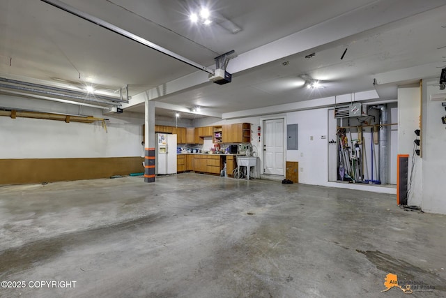 10235 Stewart Dr, Eagle River, AK 99577 - garage with white refrigerator with ice dispenser, a garage door opener, and electric panel