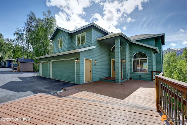 10235 Stewart Dr, Eagle River, AK 99577 - wooden deck with driveway, a garage, and a shed