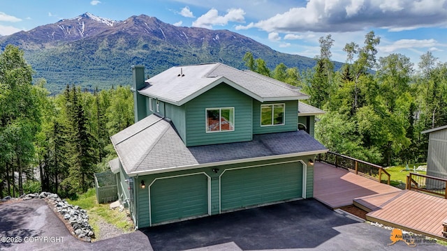 10235 Stewart Dr, Eagle River, AK 99577 - view of front of home with asphalt driveway, an attached garage, and a deck with mountain view