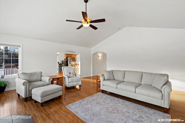 living room featuring ceiling fan, wood-type flooring, and vaulted ceiling