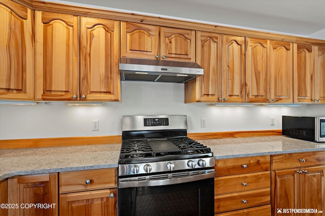 kitchen featuring light stone counters and stainless steel range with gas cooktop