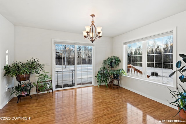 dining space with wood-type flooring and an inviting chandelier