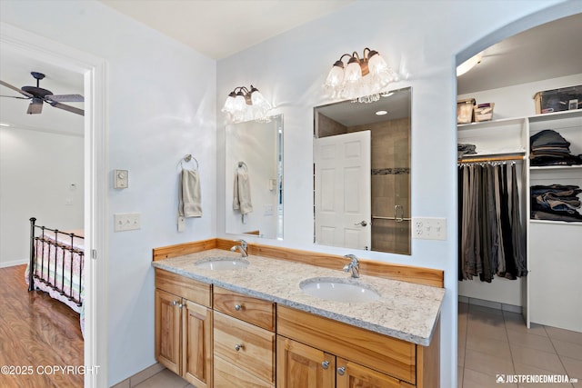 bathroom featuring vanity, a shower with shower door, tile patterned floors, and ceiling fan