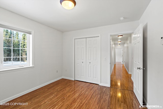 unfurnished bedroom with light hardwood / wood-style floors and a closet