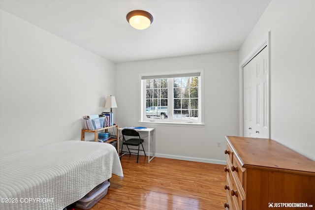 bedroom with light hardwood / wood-style flooring and a closet