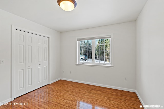 unfurnished bedroom featuring light hardwood / wood-style flooring and a closet