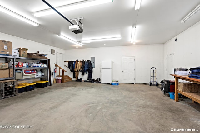 garage with white refrigerator and a garage door opener