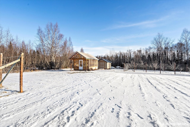 snowy yard featuring a storage shed