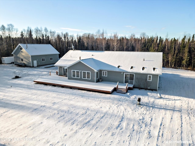 snow covered rear of property featuring a wooden deck