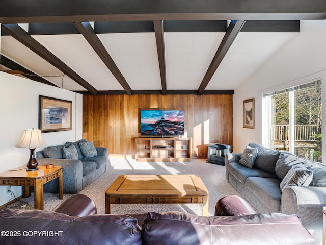 carpeted living room featuring vaulted ceiling with beams and wooden walls